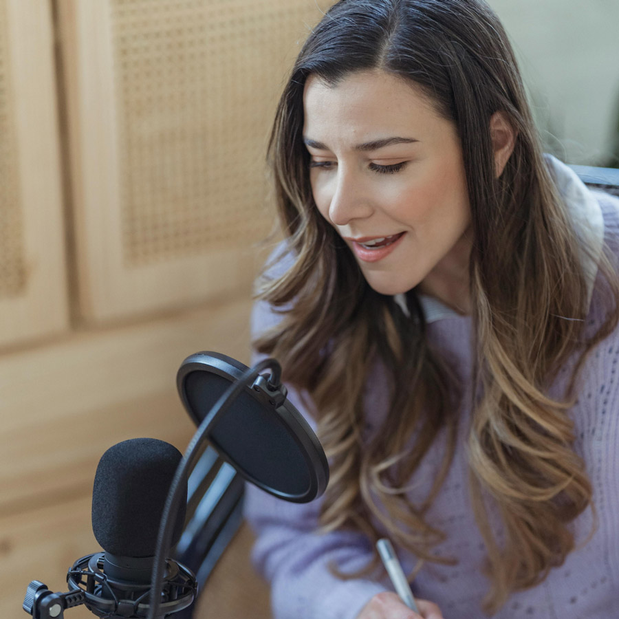 Image of a podcaster speaking into a microphone 